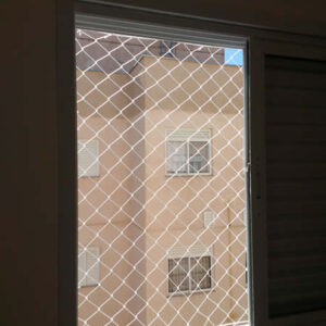 Janela de um quarto de apartamento em Curitiba com rede de proteção recém-instalada, pronta para garantir a segurança dos moradores.