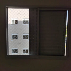 Instalação profissional de rede de proteção para pets em varanda de um prédio residencial em Curitiba, com malha pequena para segurança de gatos.